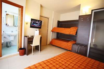 Camera d'albergo con letto a castello e scrivania.
