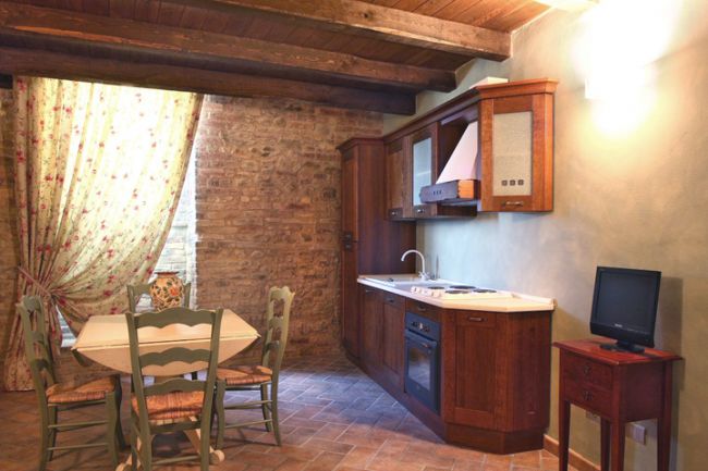 Tavolo da pranzo e cucina rustica con parete in mattoni.