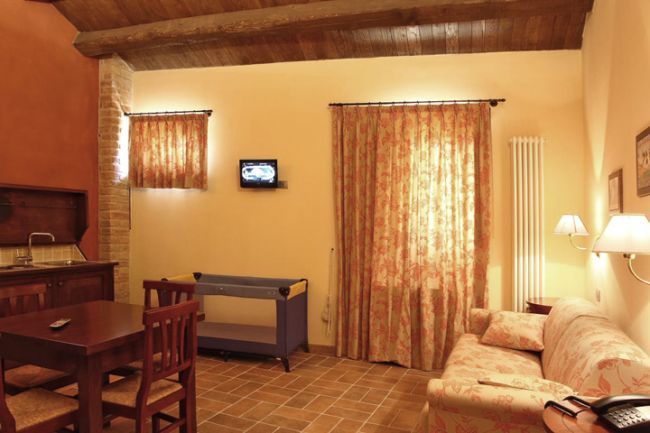 Soggiorno accogliente con divano, tavolo e TV.