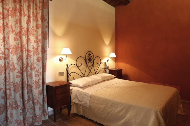 Camera da letto con letto matrimoniale e lampade a muro.