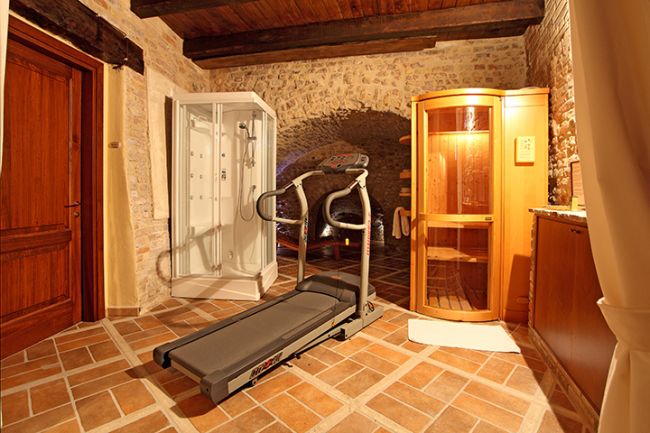 Stanza in pietra con tapis roulant e sauna.