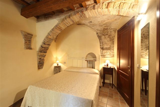 Camera da letto con soffitto ad arco in pietra.