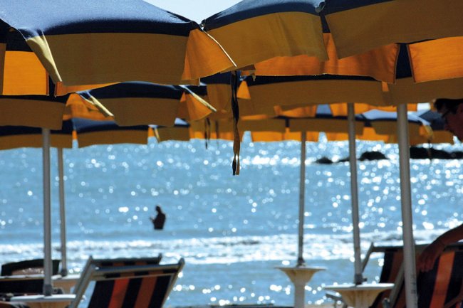 Ombrelloni gialli e blu sulla spiaggia con vista mare.