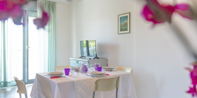 Tavolo da pranzo apparecchiato in una stanza luminosa.