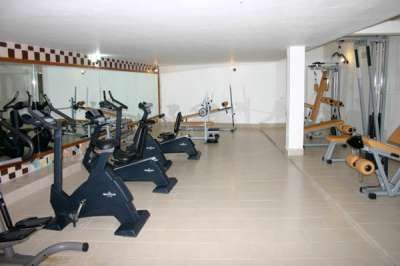 Palestra con cyclette, specchi grandi e attrezzature per esercizi.