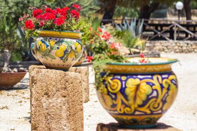 Vasi decorati con fiori rossi su colonne di pietra.