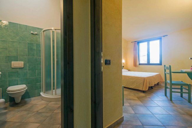 Stanza con bagno verde e camera da letto.