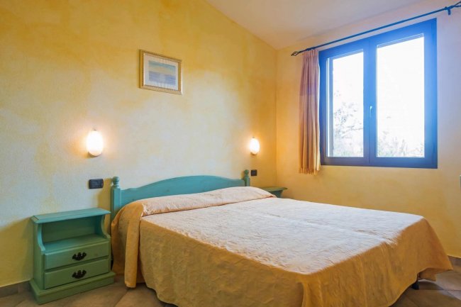 Camera da letto con due lampade e finestra.