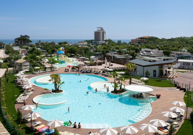 Complesso turistico con piscine e sdraio.