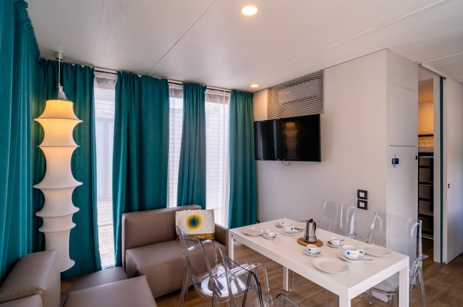 Sala da pranzo moderna con tavolo e TV.
