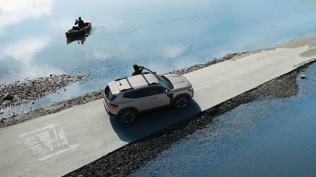 Auto su strada costiera, canoa sul lago.