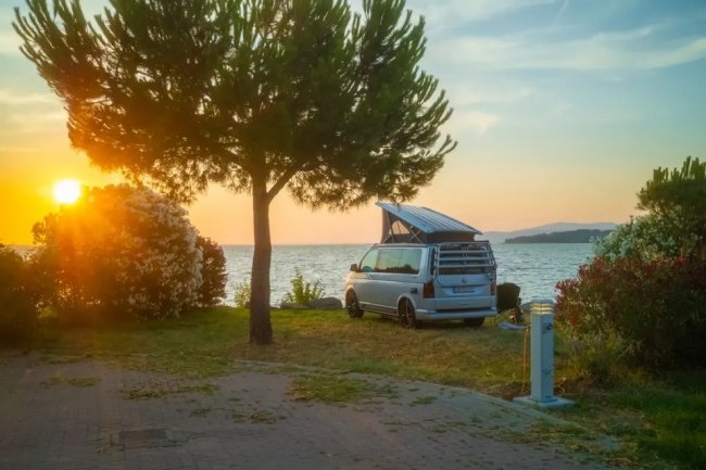 Camper al tramonto vicino a un lago.