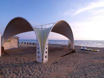 Una struttura con tetto a cupola sulla spiaggia al tramonto.