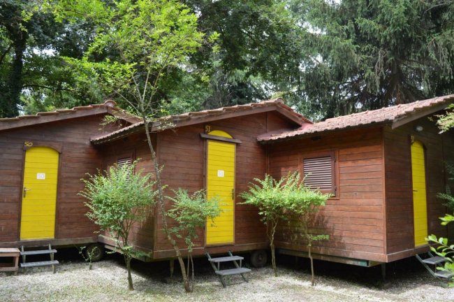 Bungalow in legno con porte gialle nel bosco.