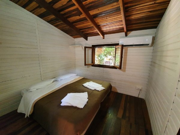 Interno di una camera con letto matrimoniale e finestra.