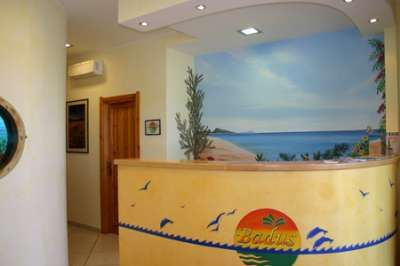 Reception con un bancone decorato e un murales di una spiaggia.