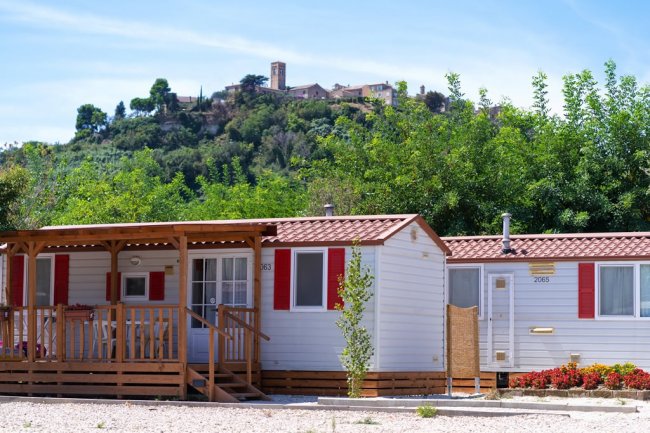 Bungalow con tetto rosso e colline sullo sfondo.