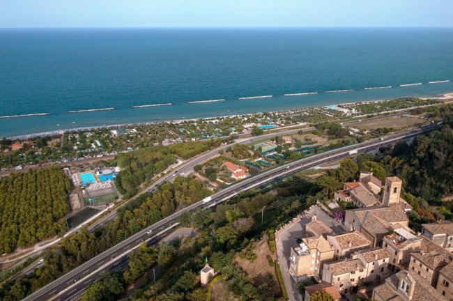 Vista aerea di una località costiera e strade.