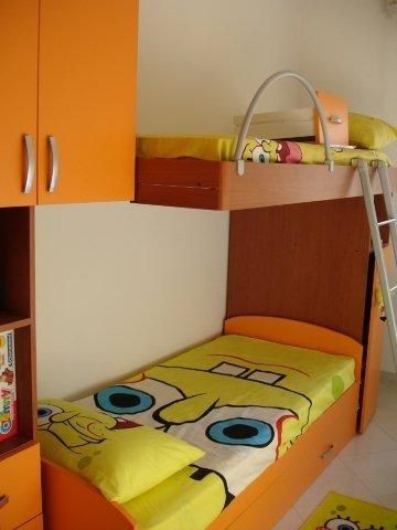 Cameretta con letti a castello arancioni e copriletto di SpongeBob.