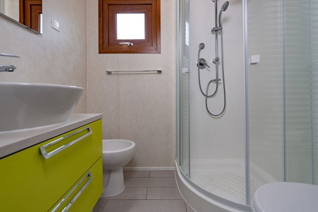 Bagno moderno con doccia e mobile verde lime.