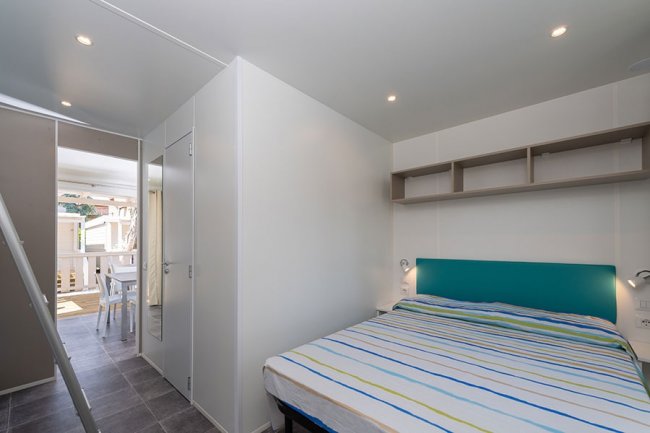 Camera con letto matrimoniale e luci soffuse.