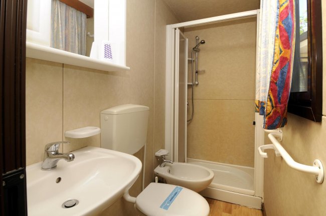 Bagno compatto con doccia, lavabo e bidet.