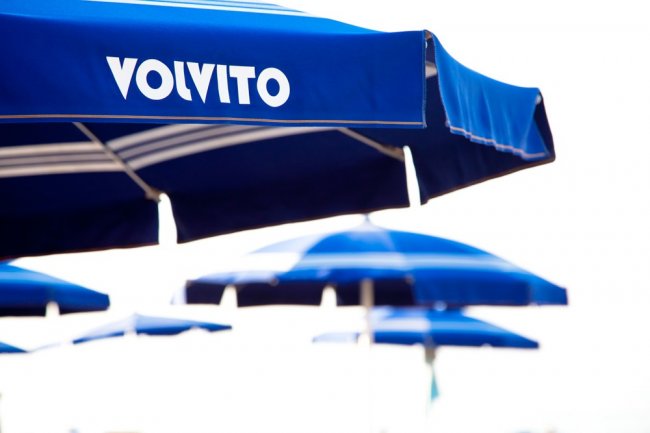 Ombrelloni blu su una spiaggia ventilata.