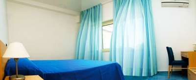 Camera con letto blu e tende azzurre.