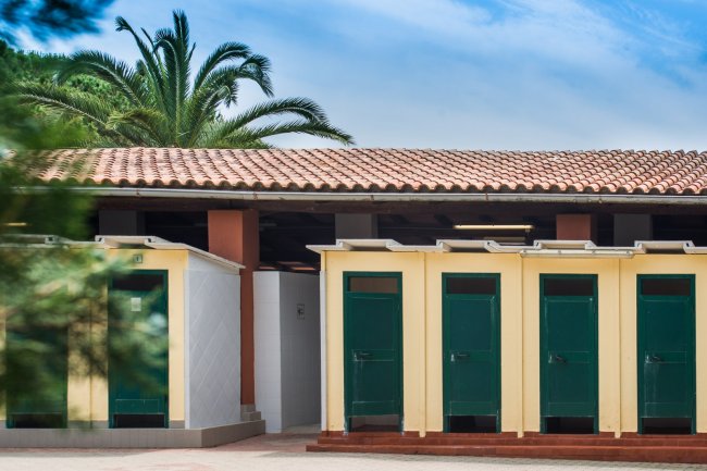Edificio con tetto in tegole e cabine con porte verdi.