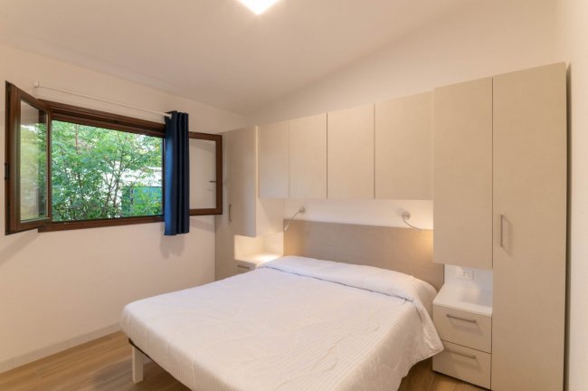 Camera da letto con letto matrimoniale e finestra.