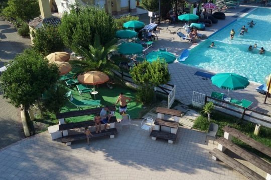 Piscina esterna con ombrelloni e lettini.