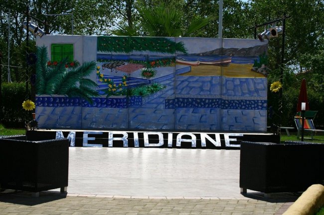 Palcoscenico all'aperto con scenario dipinto.