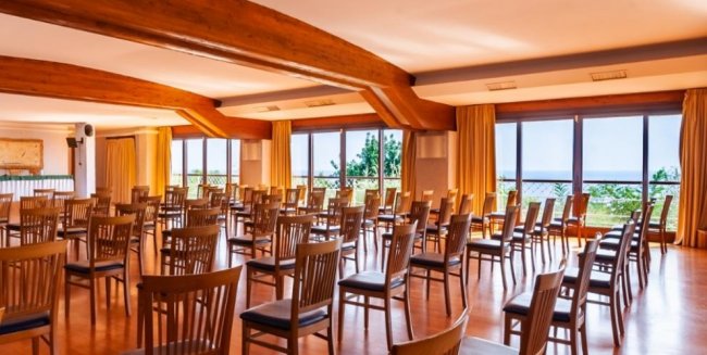 Sala conferenze con sedie disposte in file.