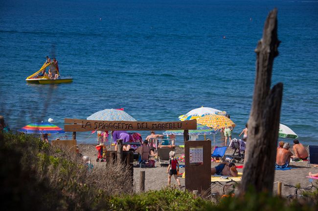 Dettaglio di una spiaggia affollata, cartello 