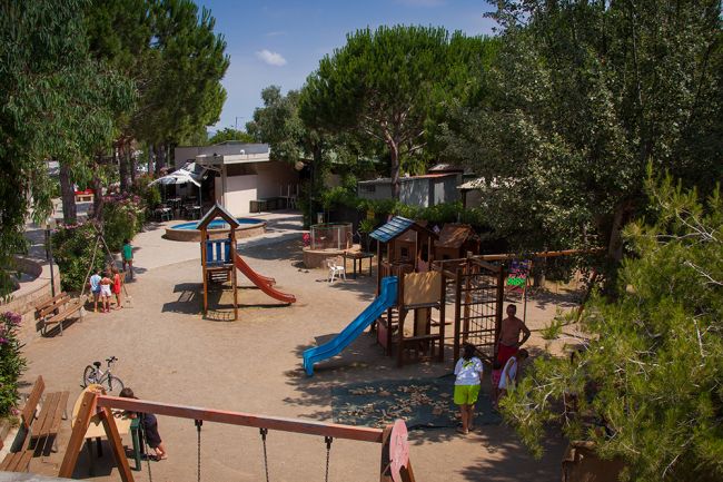 Parco giochi con scivoli e struttura in legno.