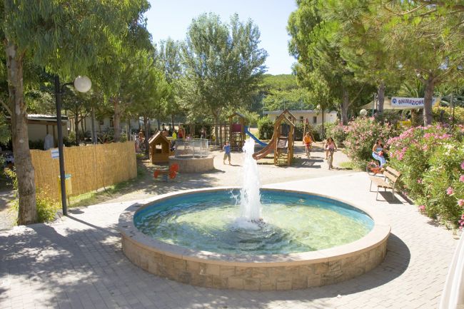 Fontana circolare vicino a un parco giochi.