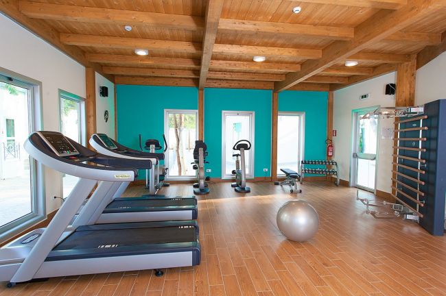 Palestra con tapis roulant e attrezzi da fitness.