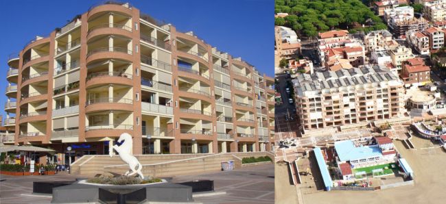 Edificio moderno con balconi e statua di cavallo bianco in primo piano.