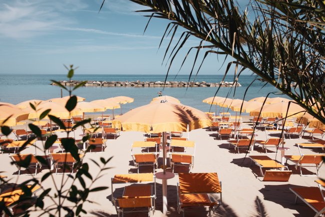 Spiaggia con ombrelloni gialli, vista mare.
