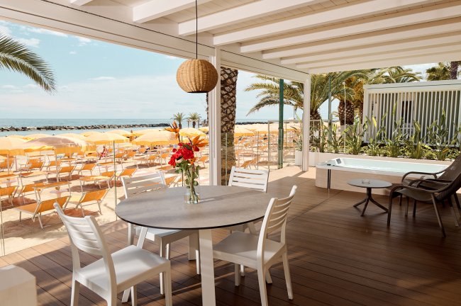 Veranda con vista mare e ombrelloni gialli.
