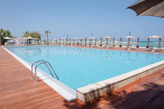 Piscina ampia con bordo in legno.