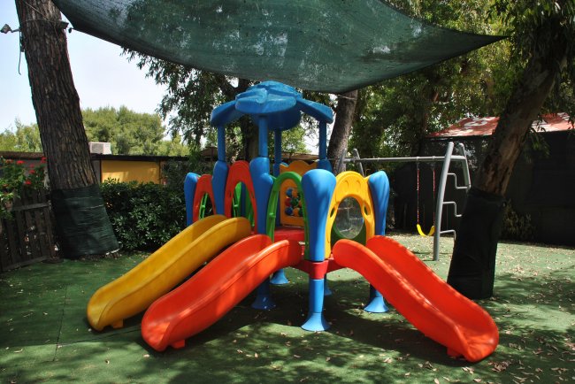 Un'area giochi per bambini con scivoli colorati e altalene.
