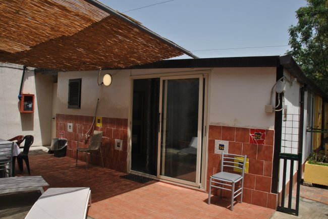 Struttura con pareti rosse e sedie fuori.