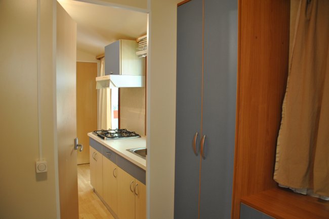 Interno cucina con fornelli e armadi.