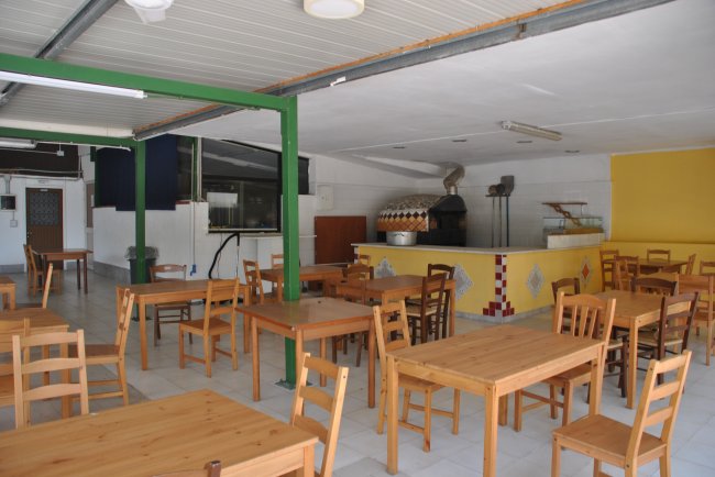 Sala da pranzo con tavoli in legno e forno.