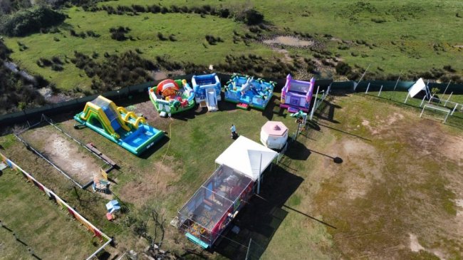 Area giochi con gonfiabili su prato verde.