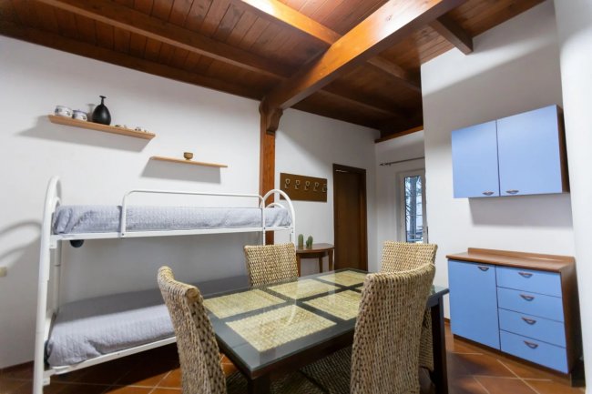 Tavolo da pranzo con letti a castello in stanza.
