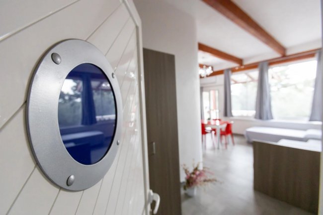 Ingresso con vista salotto e sedie rosse.