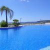 Una piscina a sfioro con vista sul mare e palme sul bordo.