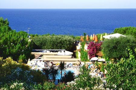 Vista su mare, piscina e vegetazione variopinta.